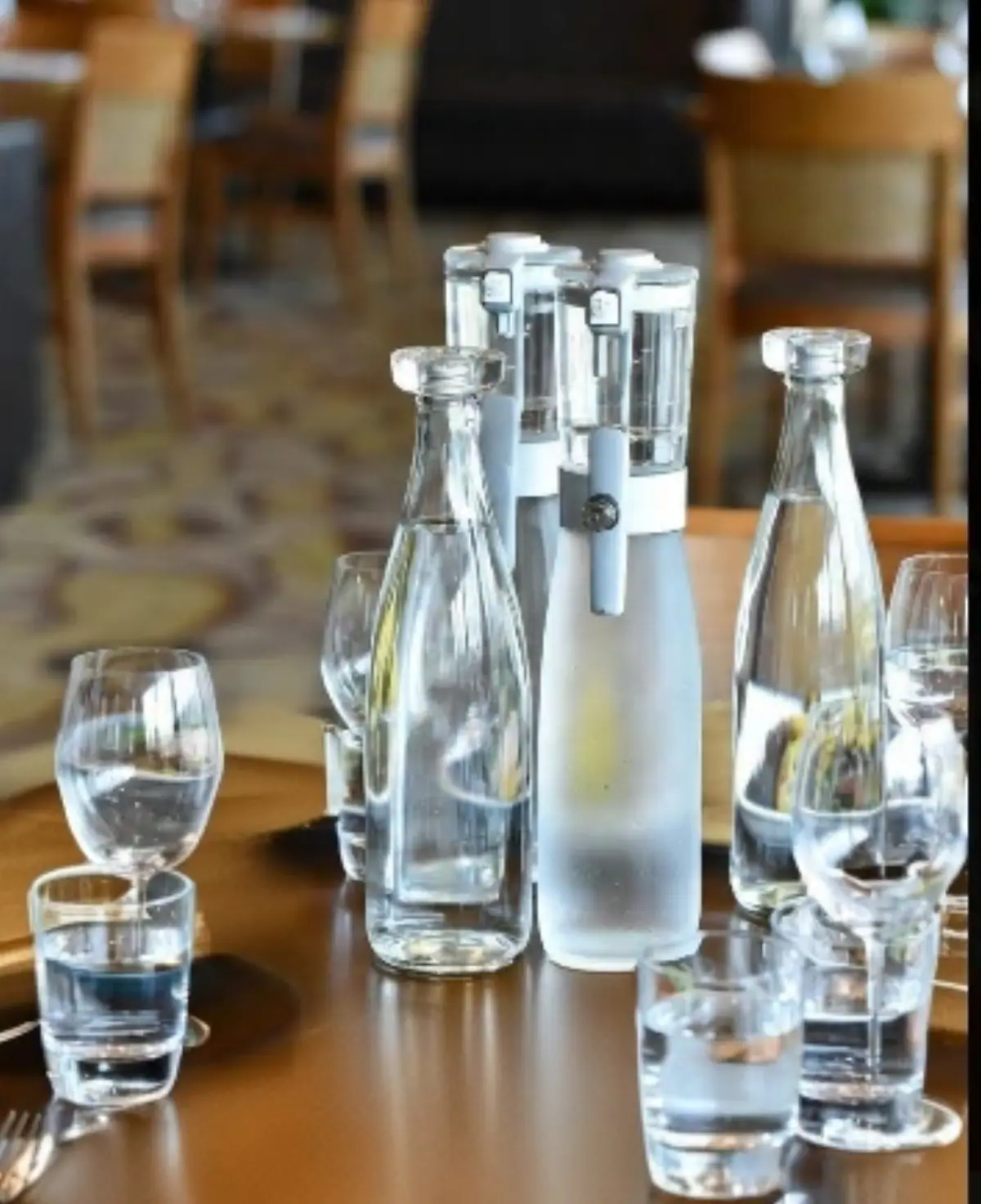 Sopra un tavolo all'interno di un ristorante bicchieri e Bottiglia di acqua in Vetro