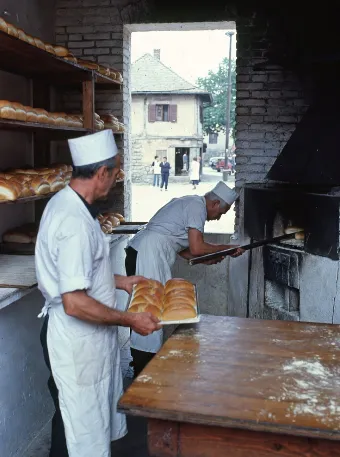 Forno di paese anni 80. Persone che sfornano il pane