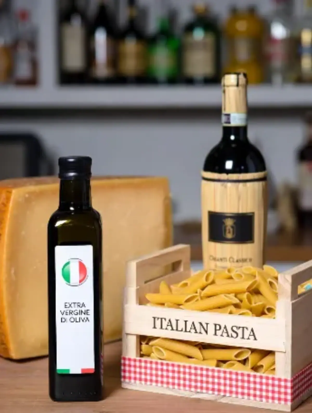 Formaggio, una bottiglie di olio extravergine d'oliva e due cassette con dentro pasta fresca con scritta "italian pasta"