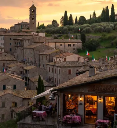 borgo italiano visto da lontano con l’osteria ben visibile e illuminata.