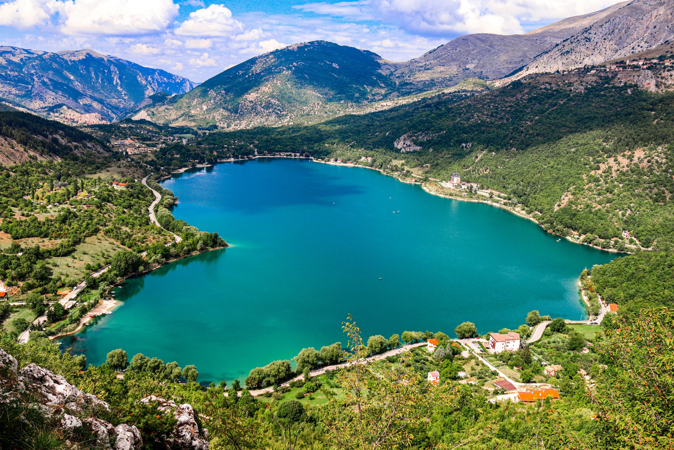 Vista panoramica del Lago di Scanno a forma di cuore immerso nelle montagne dell’Abruzzo con acque turchesi e vegetazione circostante