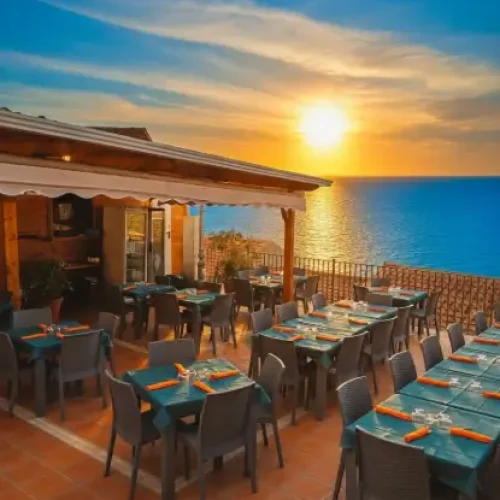 Terrazza panoramica del Ristorante Sapori del Borgo a Rocca Imperiale con vista mozzafiato sul mare Ionio al tramontoTitolo:Cena con Vista sul Mare a Rocca Imperiale